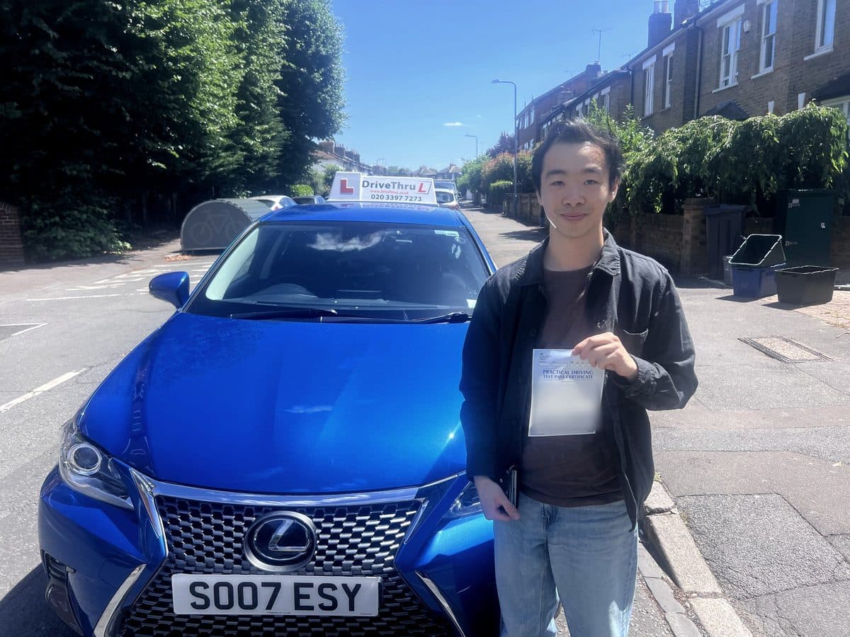 A DriveThruL pupil from Canary Wharf with his pass certificate beside the driving school car, after passing at Wanstead test centre