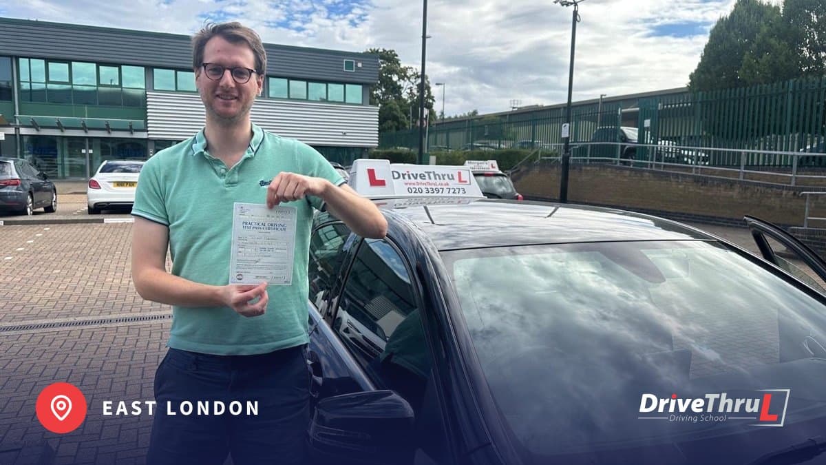 DriveThruL pupil with his pass certificate beside the car