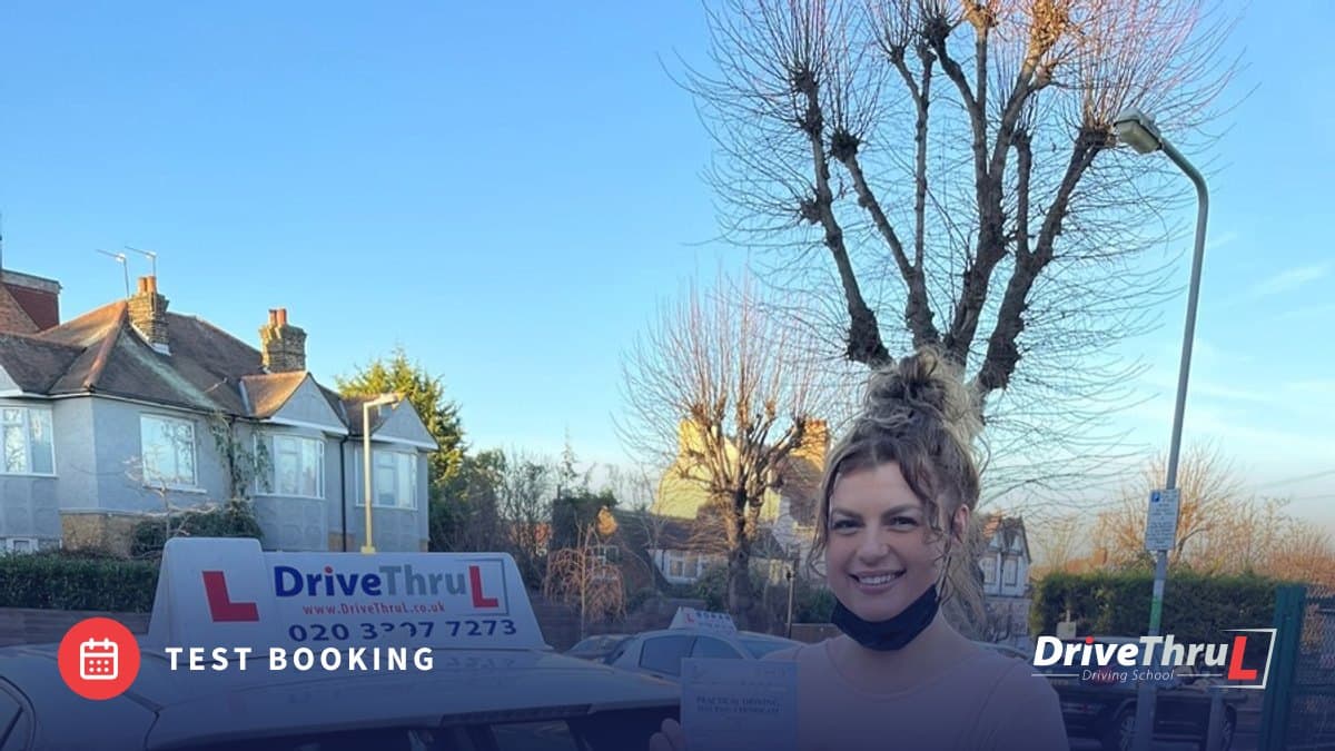 DriveThruL pupil with a pass certificate beside the car
