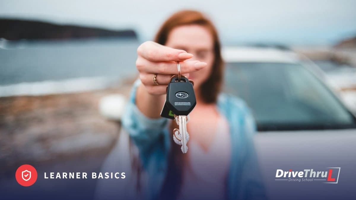Young driver holding out a car key