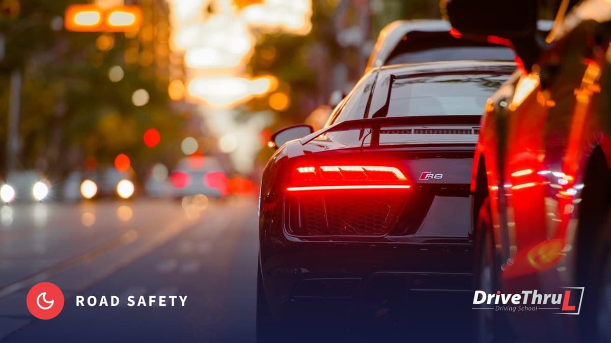 DriveThruL Driving Hub card: Driving after dark. City traffic at dusk with red tail lights