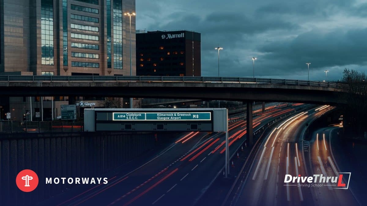 Motorway at dusk with a blue overhead direction sign