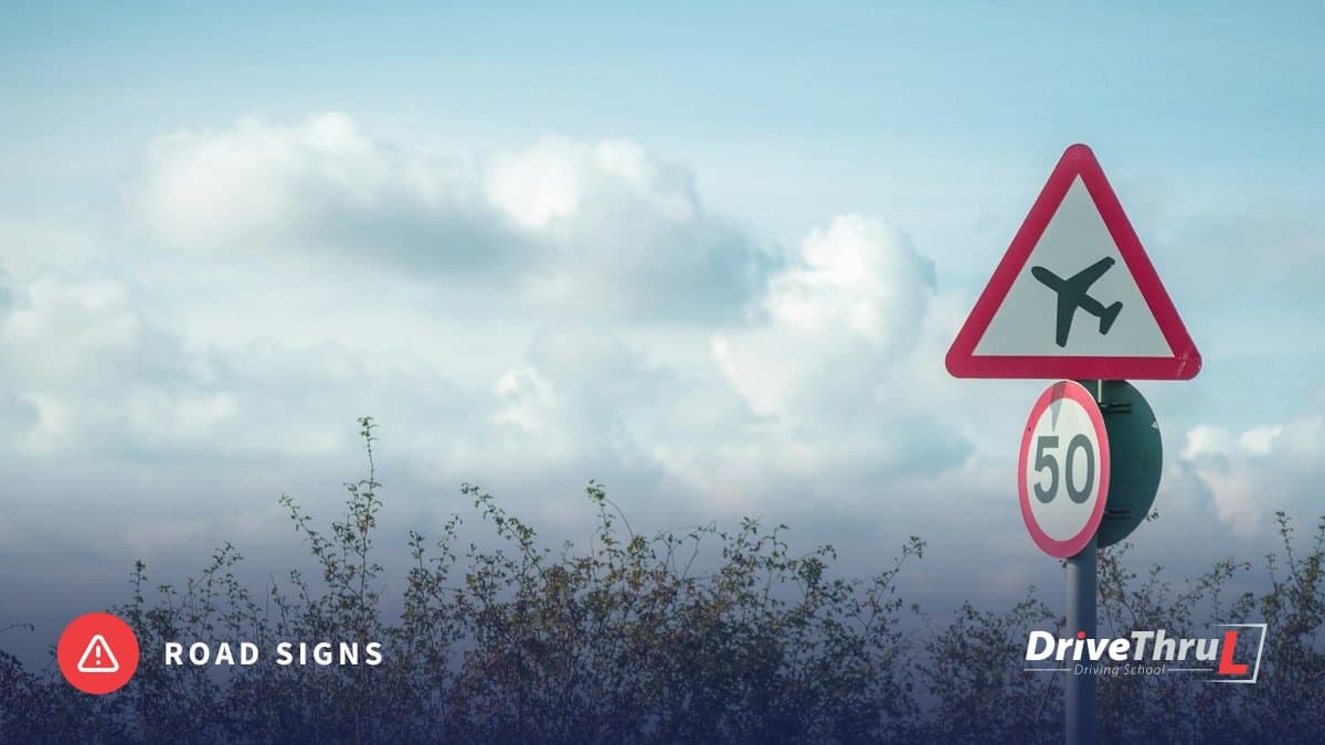 Red triangle warning sign for low-flying aircraft above a 50 limit sign