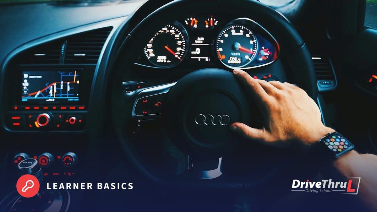DriveThruL Driving Hub card: Your first lesson, step by step. Driver’s hands on the steering wheel, seen from the back seat