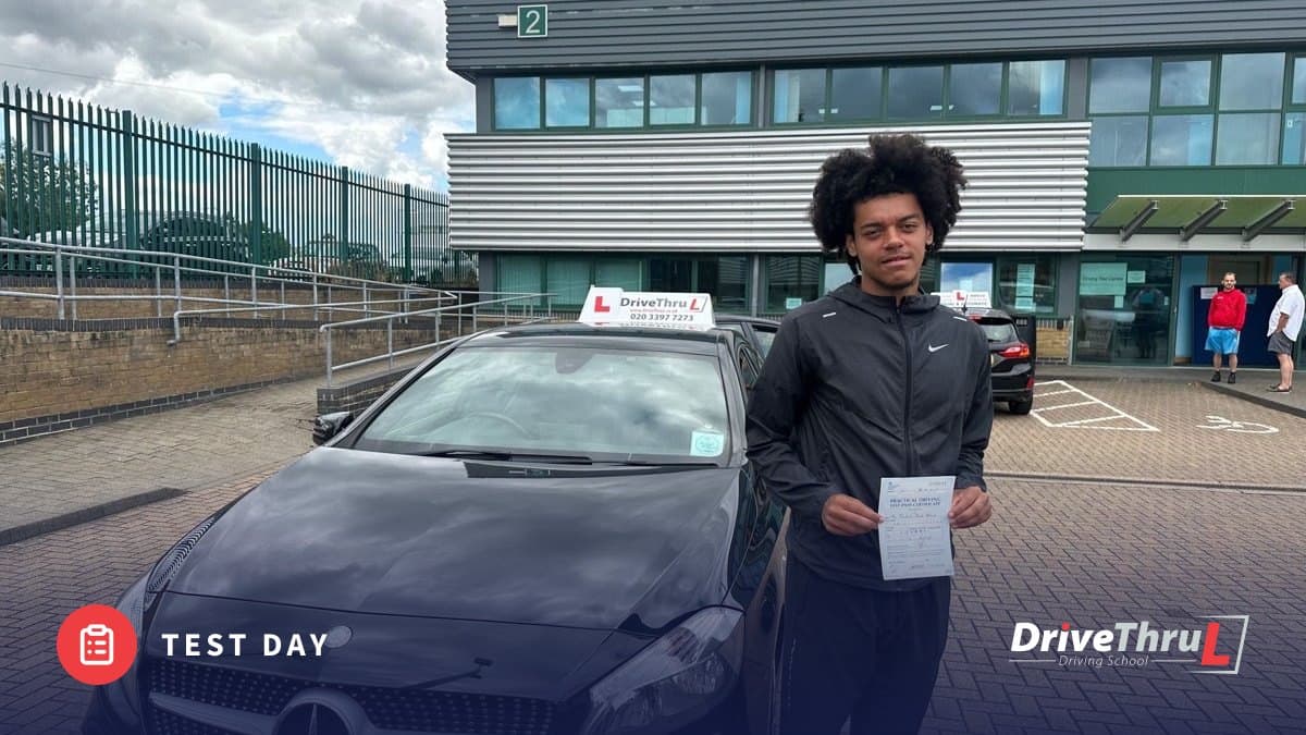 DriveThruL pupil with his pass certificate beside the car at the test centre