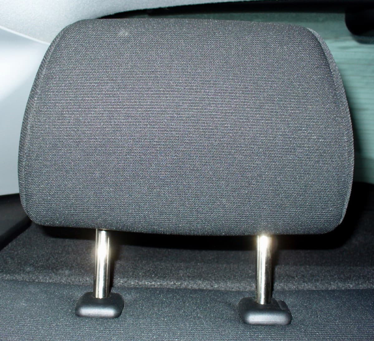 A car seat head restraint on its two metal posts