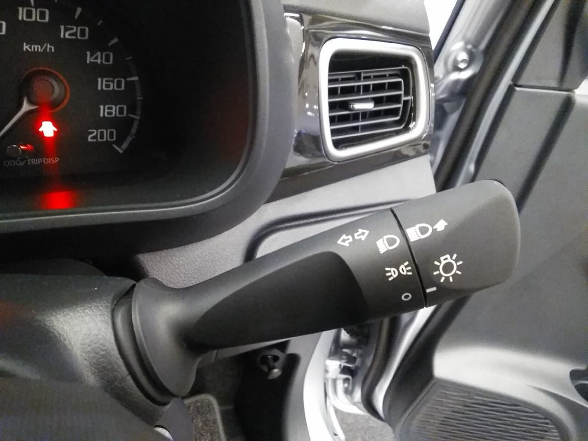 An indicator stalk with arrow symbols beside the steering wheel