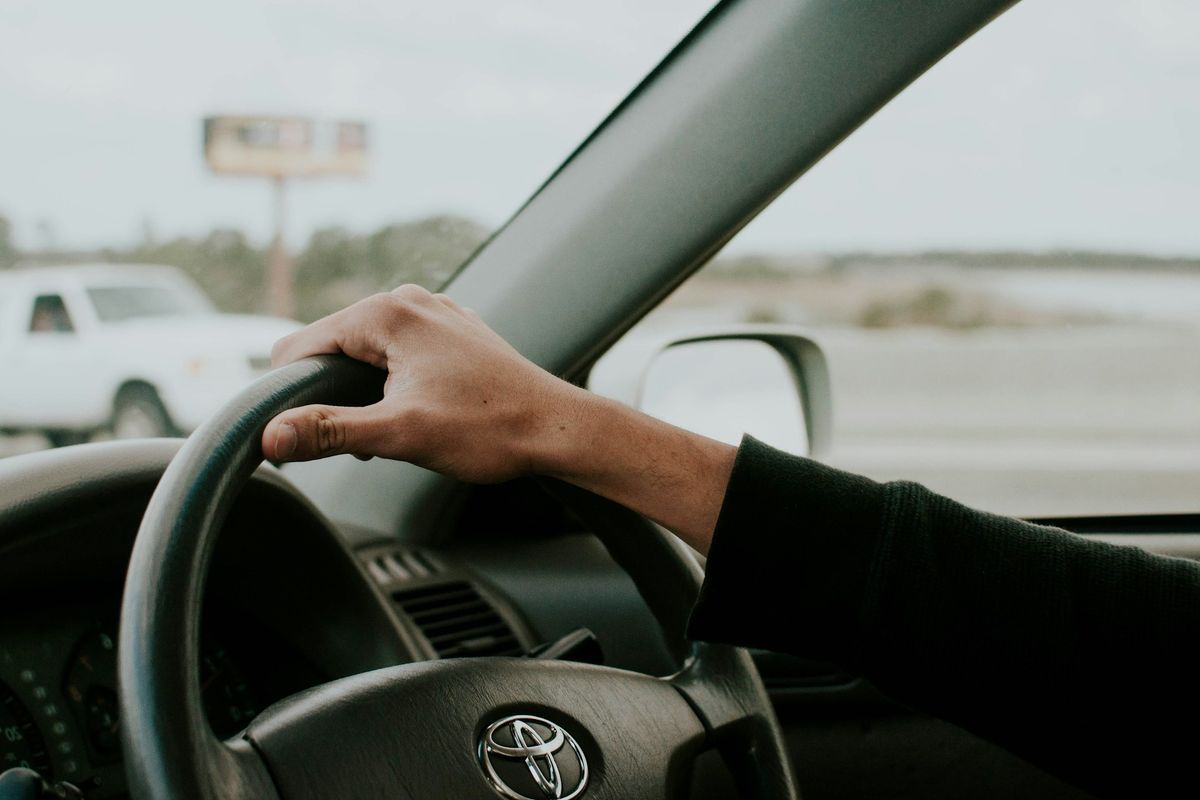 Driver’s hand on the steering wheel of a right-hand-drive car