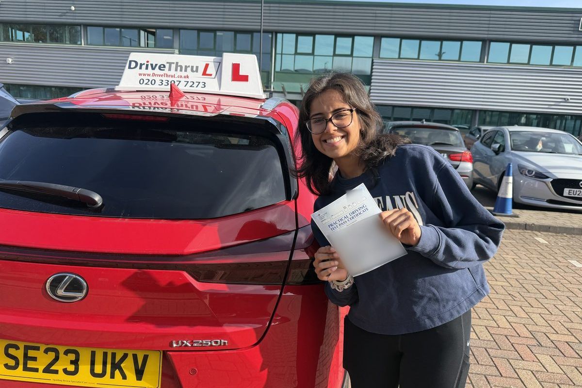 DriveThruL pupil with her pass certificate beside the car