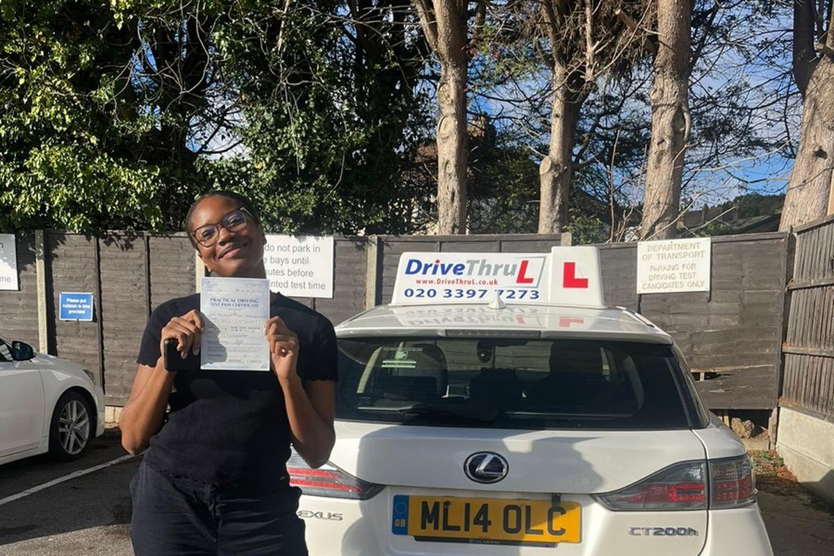 DriveThruL pupil with her pass certificate beside the car