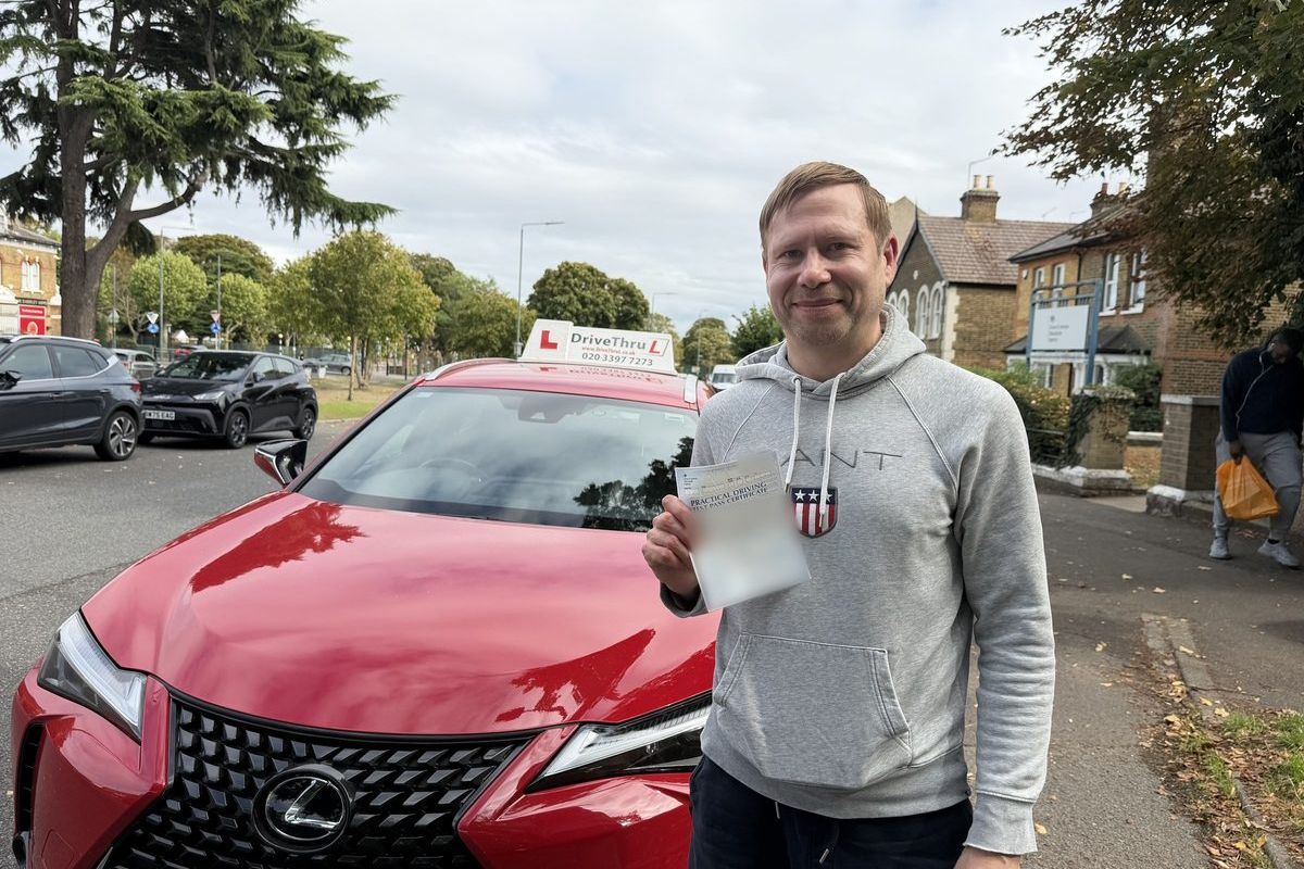 DriveThruL pupil with his pass certificate beside the car