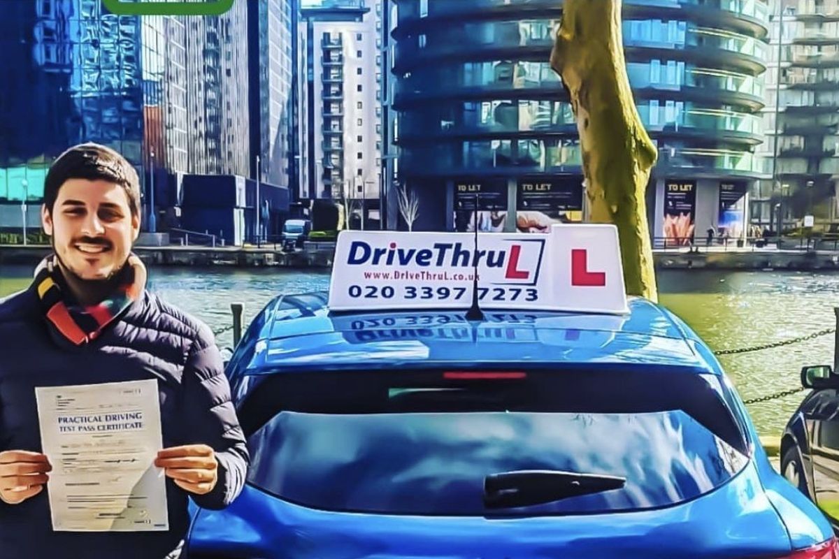 DriveThruL pupil with his pass certificate beside the car