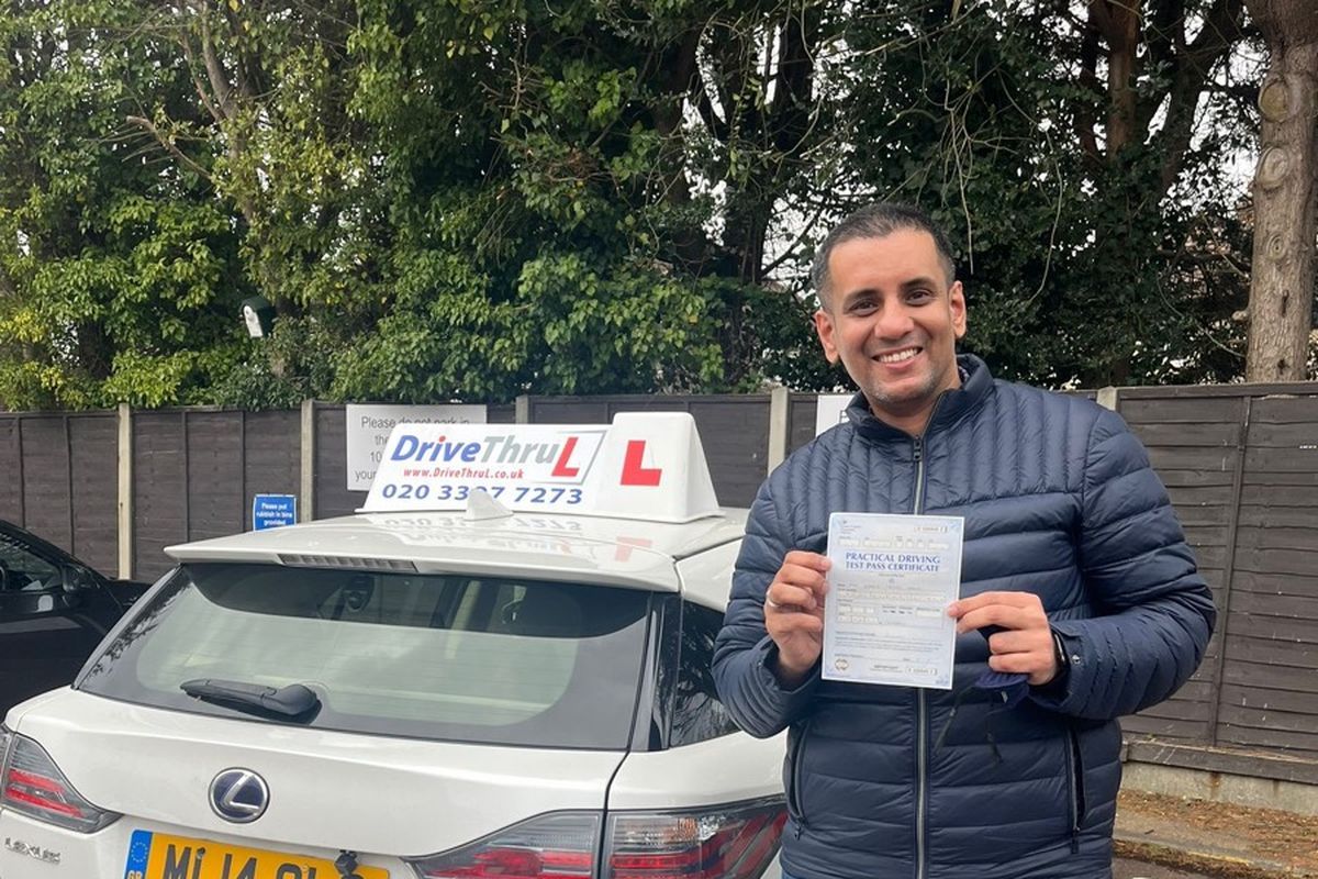 DriveThruL pupil with his pass certificate beside the car